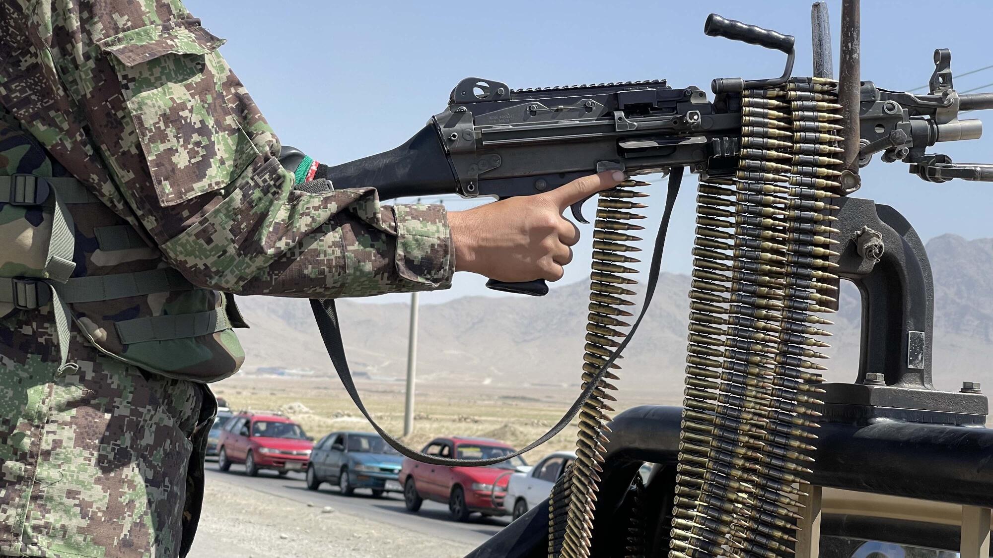 An Afghan soldier stands guard at a checkpoint near the Bagram airfield.