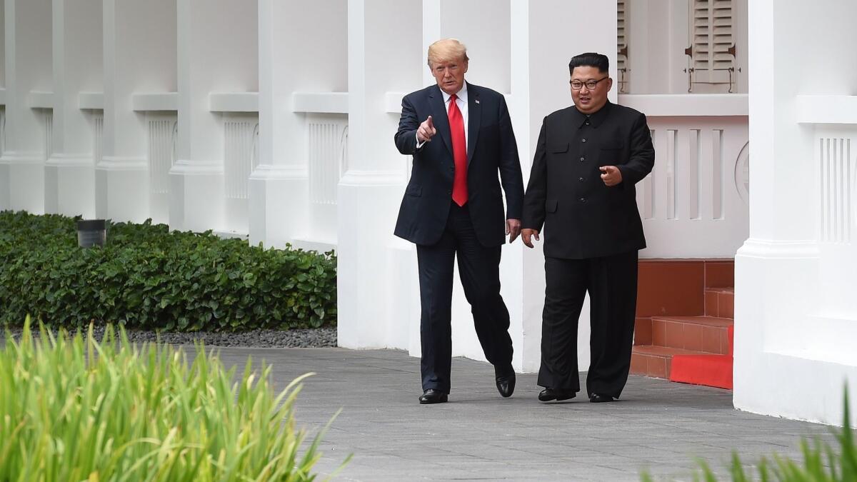 President Trump and North Korean leader Kim Jong Un take a walk during a break in talks at their historic summit at the Capella Singapore hotel on June 12, 2018.