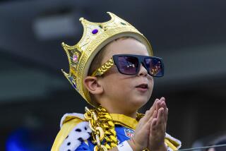 Chargers fan Aidan Blumberg, 6, seems to be praying during game against the Cowboys.