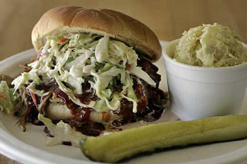 A pulled pork sandwich topped with coleslaw and barbecue sauce at Scottie's Smokehouse in Orange.