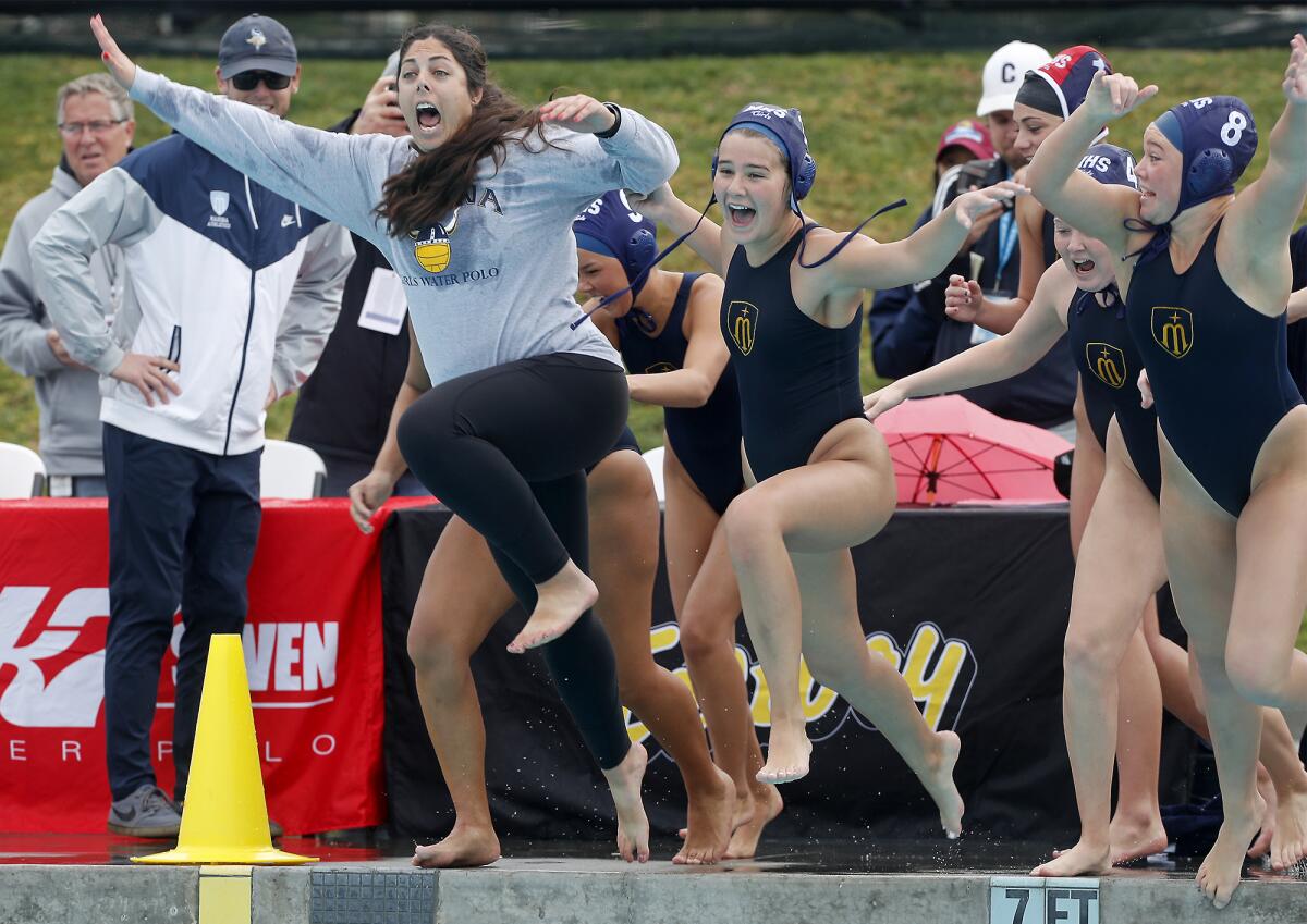 Marina coach Tamara Towgood, left, jumps in the pool with her players to celebrate the Vikings' win in the CIF Southern Section Division 6 girls' water polo final on Saturday at Woollett Aquatics Center.