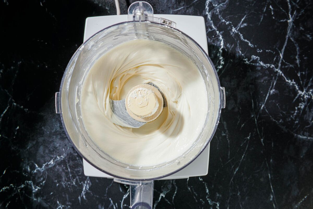 A food processor with whipped ricotta.