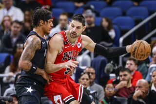 El montenegrino Nikola Vucevic, de los Bulls de Chicago, trata de avanzar frente a Pablo Banchero, del Magic de Orlando, en el encuentro del sábado 28 de enero de 2023 (AP Foto/Kevin Kolczynski)