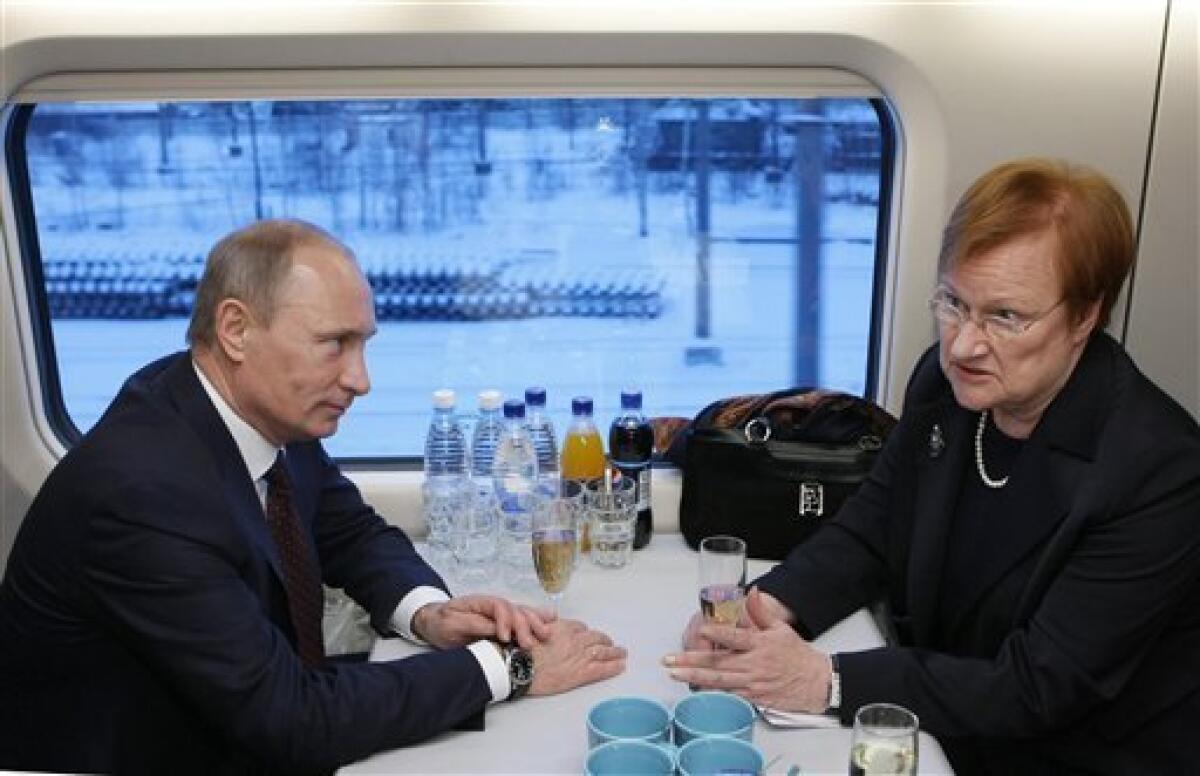 Russian Prime Minister Vladimir Putin, left, and Finnish President Tarja Halonen chat in the high speed train at the railway station in Vyborg, Russia, some 160 km (100 miles) west of St. Petersburg, Sunday, Dec. 12, 2010. Halonen and Putin inaugurated the first high-speed rail link between the EU and Russia as new trains start running between Helsinki and St. Petersburg, shortening travel time by nearly half, boosting business travel and tourism.(AP Photo/RIA Novosti, Alexei Nikolsky, Pool)