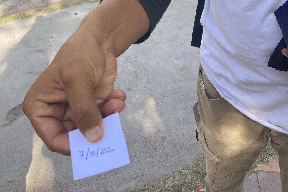 Un migrante muestra un papel con la fecha en que fue citado por la Casa del Migrante de Piedras Negras