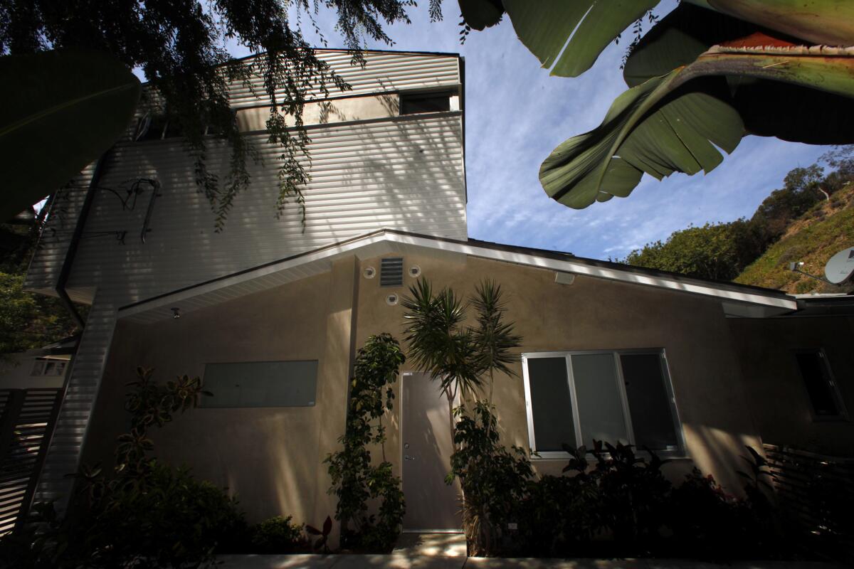 A side view of Todd Conversano's home shows where the new structure rests slightly above the old structure, with the gap masked by the aluminum facade.