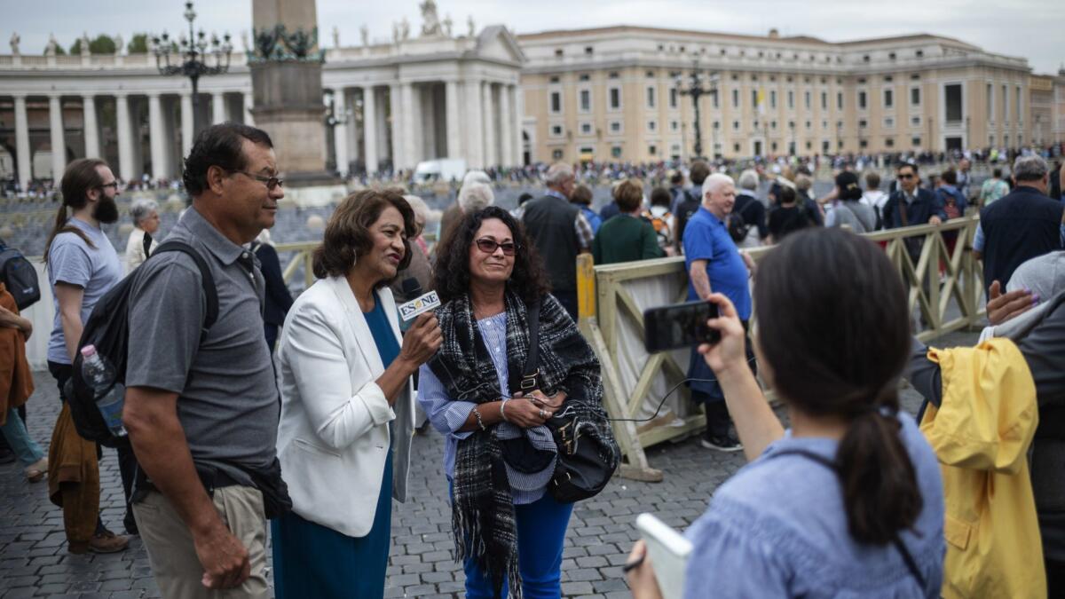 Maria Hilda Gonzalez, second from left, interviews pilgrims, many from El Salvador and Los Angeles, who flocked to St. Peter's Square in Vatican City for Archbishop Oscar Romero's canonization.