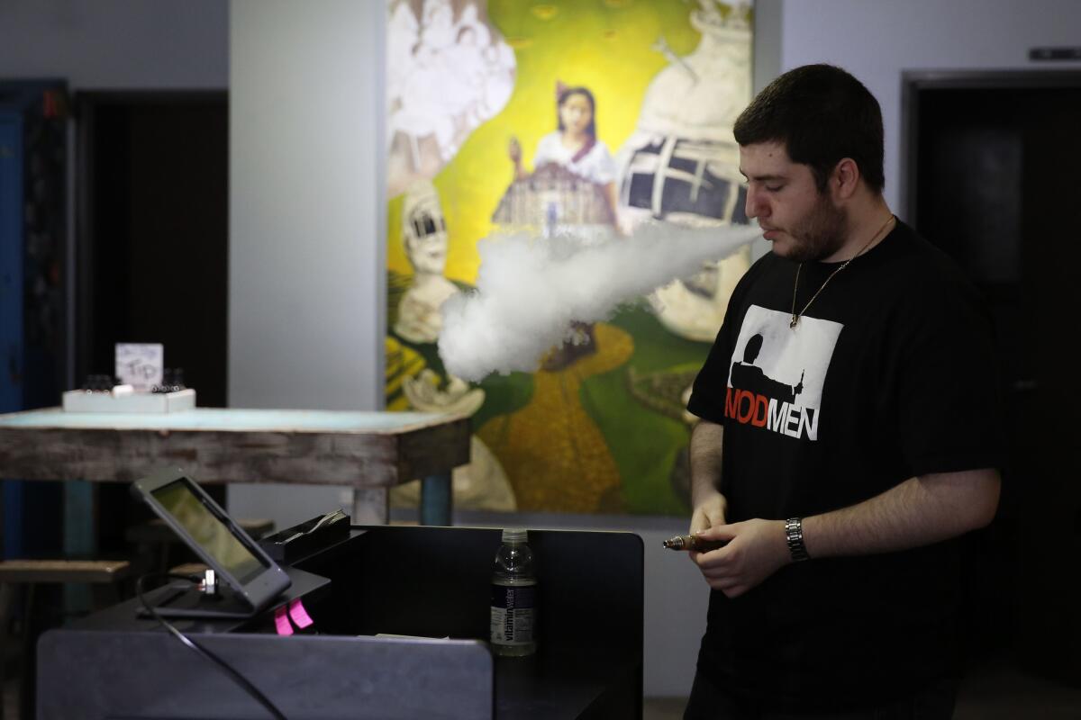 Reese Flores, owner, smokes an e-cigarette at Vapegoat in Highland Park last year.