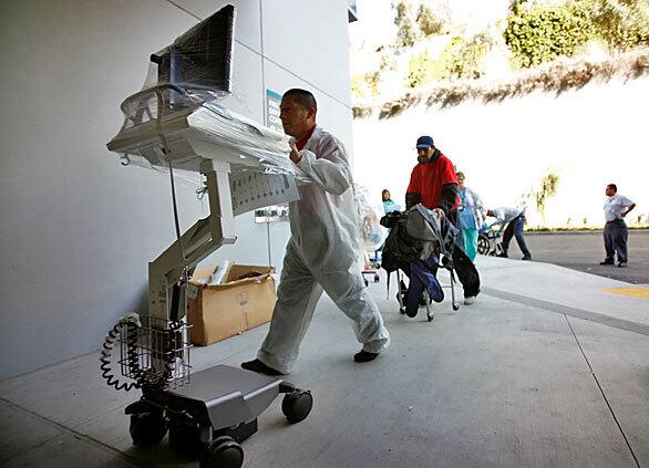A Kaiser Permanente employee moves medical equipment into Kaiser's new hospital on Sunset Boulevard in Hollywood. The $600-million facility has 465 beds. The old hospital next door will eventually be torn down.