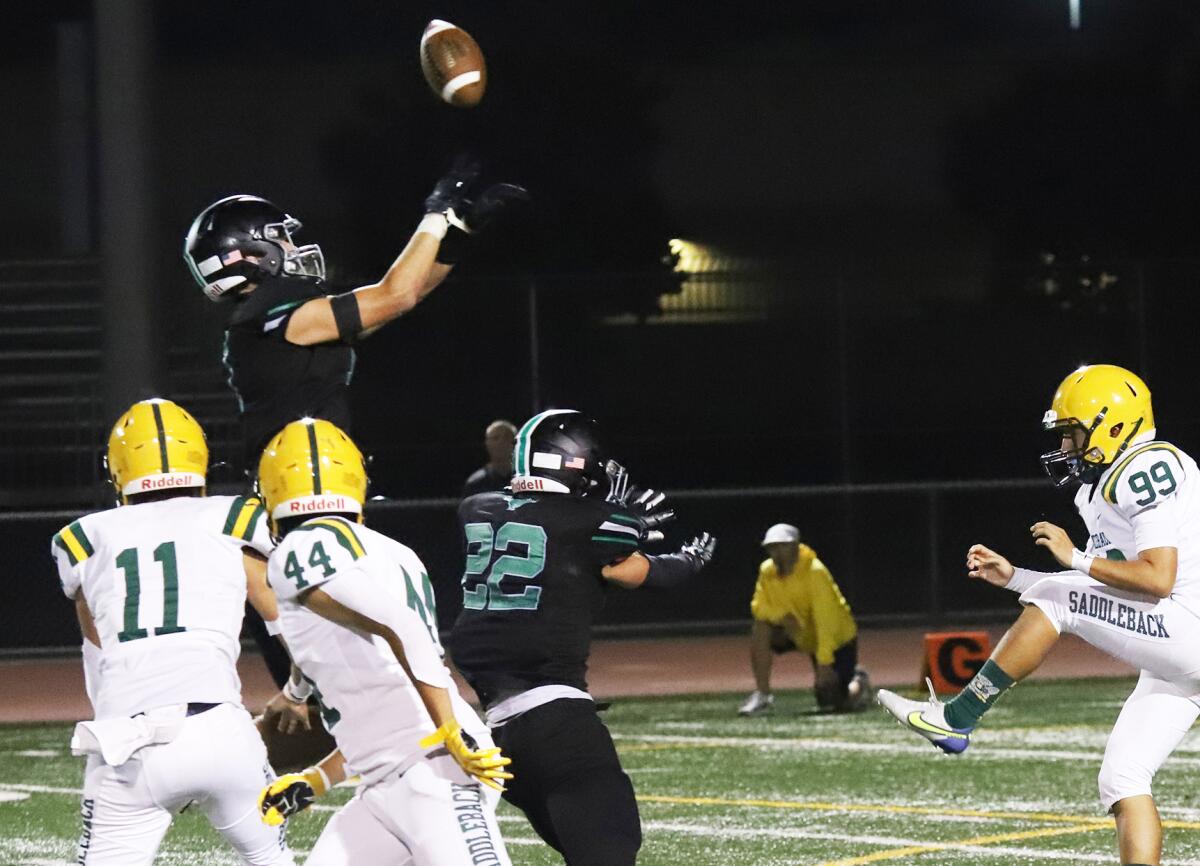 Costa Mesa's Riley Weinstein (11) blocks a punt in the second quarter against Saddleback on Friday.