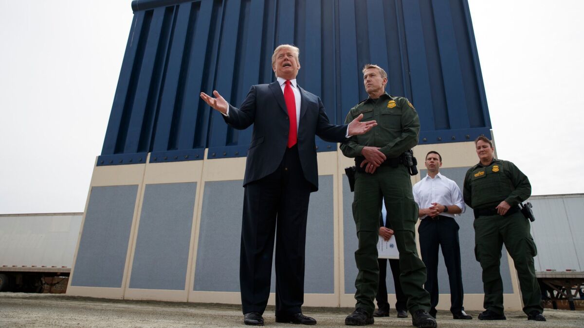 President Trump talks with reporters as he reviews border wall prototypes in San Diego on March 13.