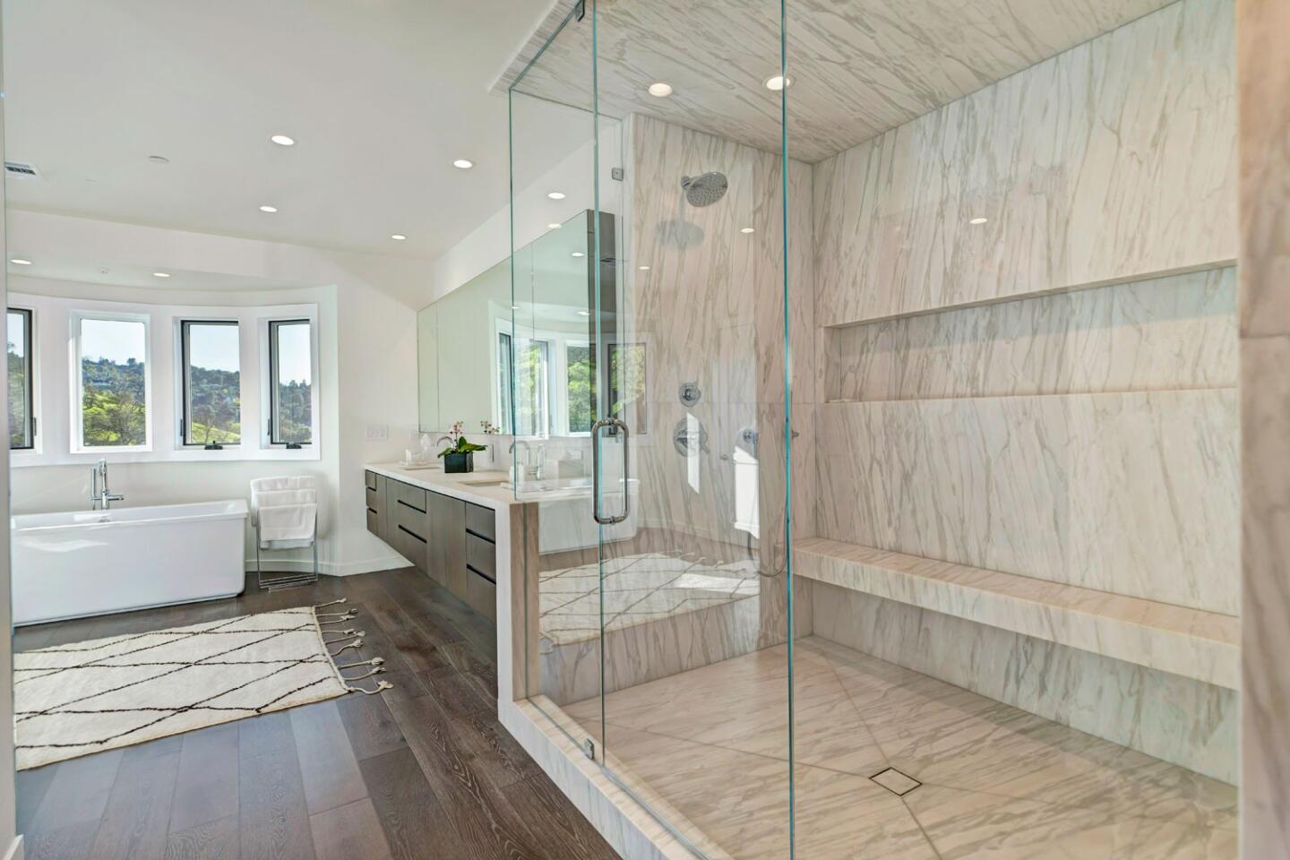 The master bath is spa-like with an ample use of marble and glass.