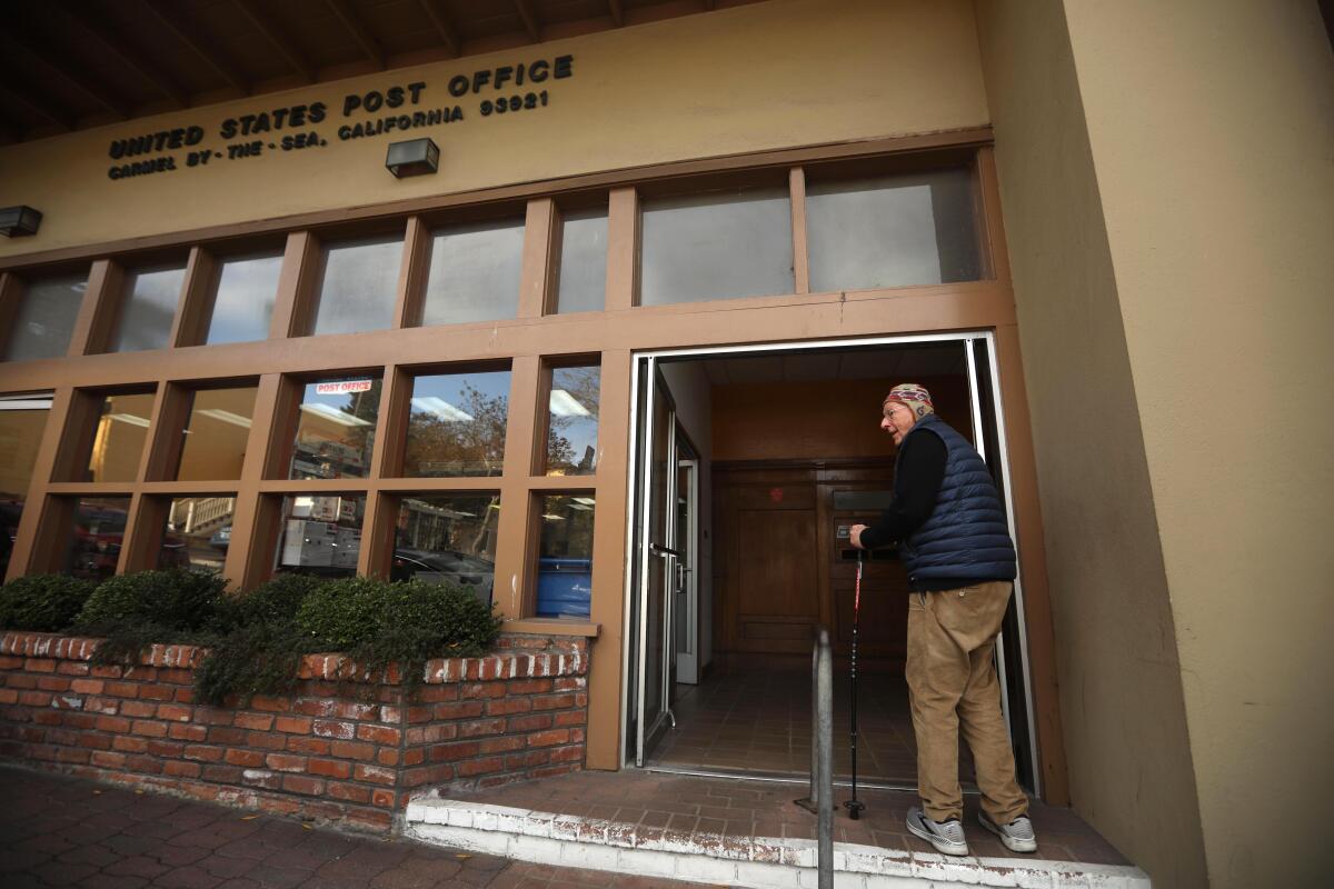 A man stands outside the post office in Carmel-by-the-Sea. 