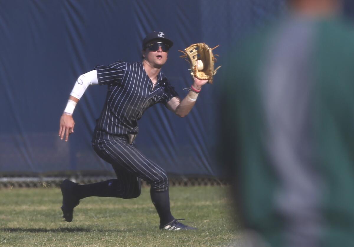 Newport Harbor outfielder Ryan Williams runs down a deep fly ball for an out against Edison on Friday.