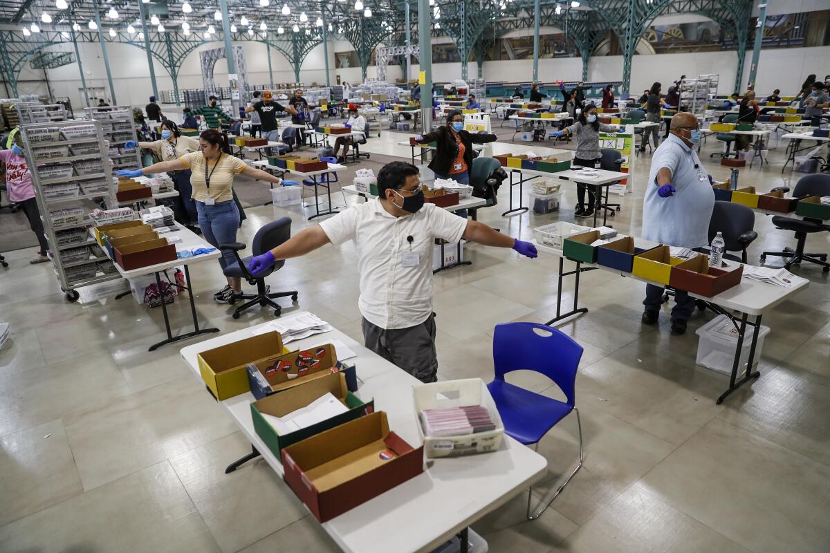 People standing at individual tables with open boxes stretch their arms 