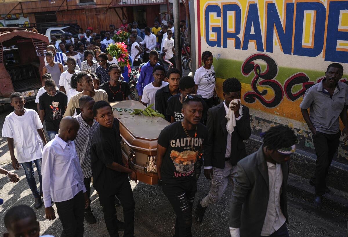 Friends and family accompany the coffin that contains the remains of Jhon-Roselet Joseph, killed by a stray bullet.