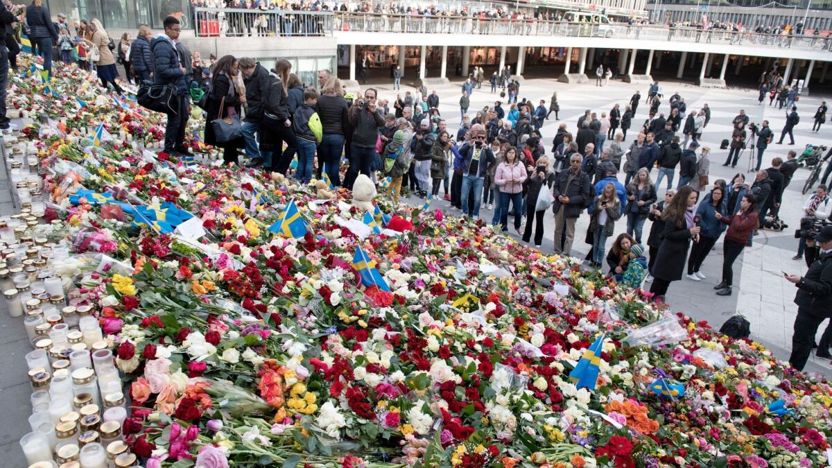 People leave flowers at the public area Sergels Torg in Stockholm on Sunday to commemorate the people killed and injured in Friday's truck attack.