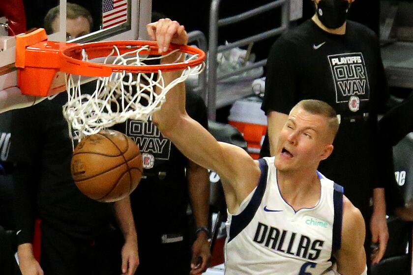 LOS ANGELES, CA - MAY 22:. Mavericks center Kristaps Porzingis throws down a slam dunk against Clippers forward Kawhi Leonard late in the fourth quarter to seal a 113-103 victory in Los Angeles on Saturday, May 22, 2021 in Los Angeles, CA. (Luis Sinco / Los Angeles Times)