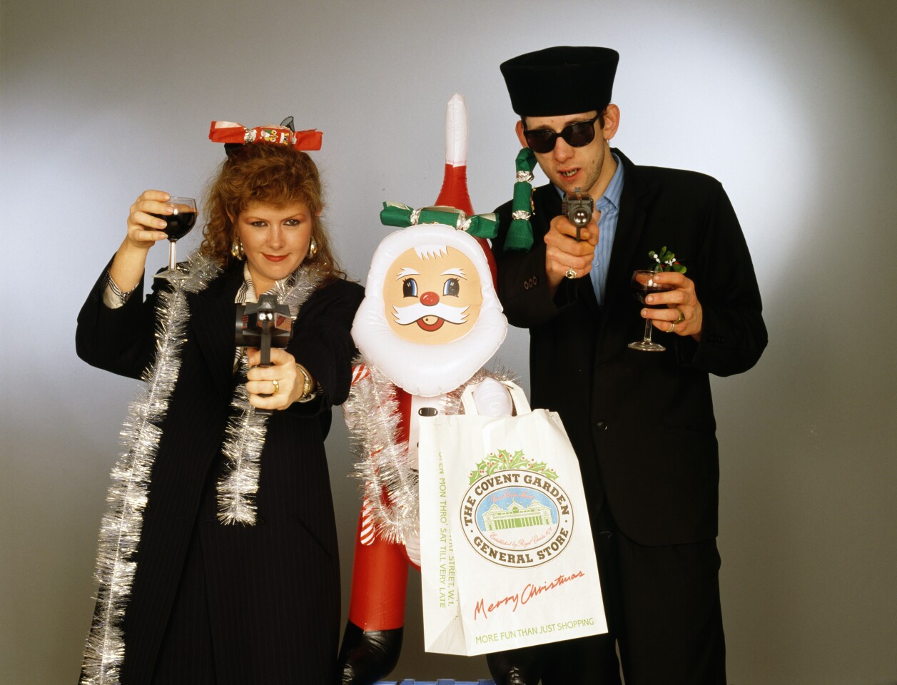 Singers Kirsty MacColl and Shane MacGowan with with toy guns and an inflatable Santa, 1987.