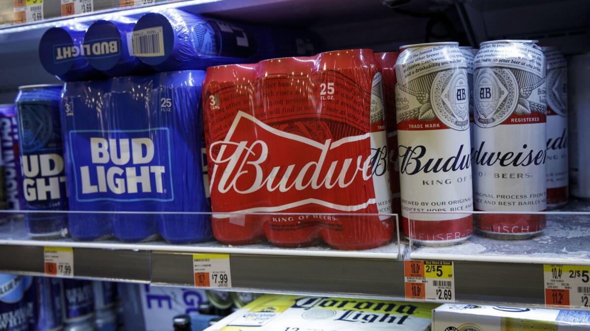 Cans of Budweiser and Bud Light sit for sale on a convenience store shelf in New York.