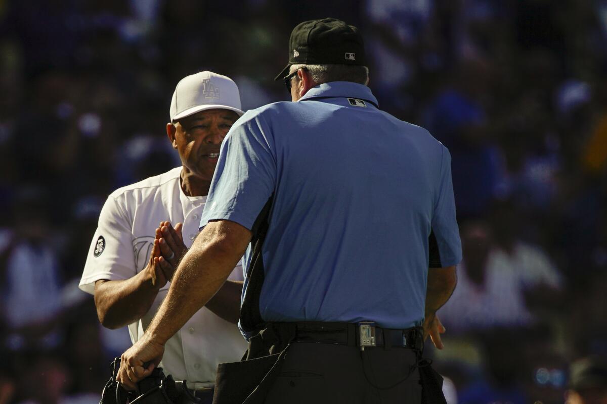 Dodgers manager Dave Roberts talks with the home plate umpire during Sunday's loss to the New York Yankees.