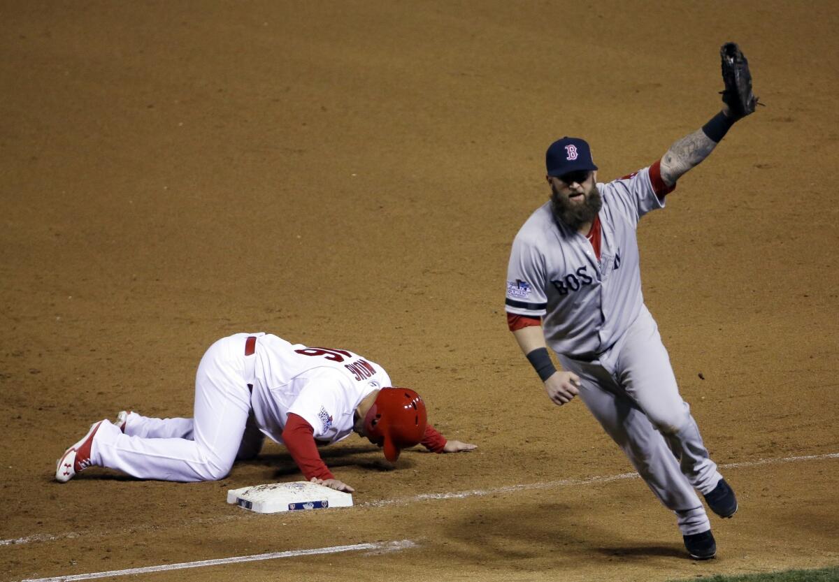Boston Red Sox first baseman Mike Napoli, right, celebrates after tagging out St. Louis Cardinals pinch-runner Kolten Wong on a pick-off throw to end Game 4 of the World Series on Sunday.