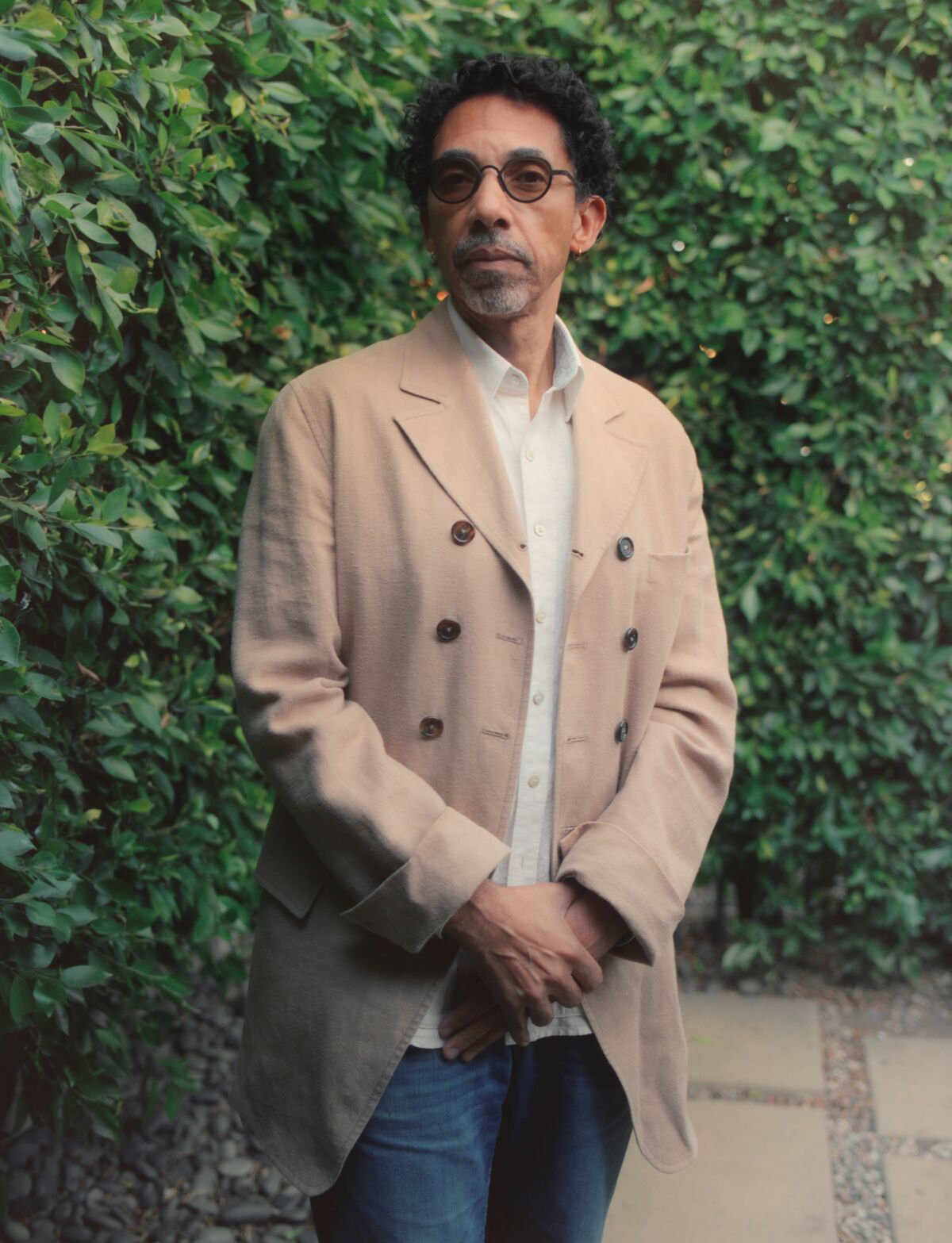 Historian/writer Robin D.G. Kelley stands outdoors in front of a shrub.