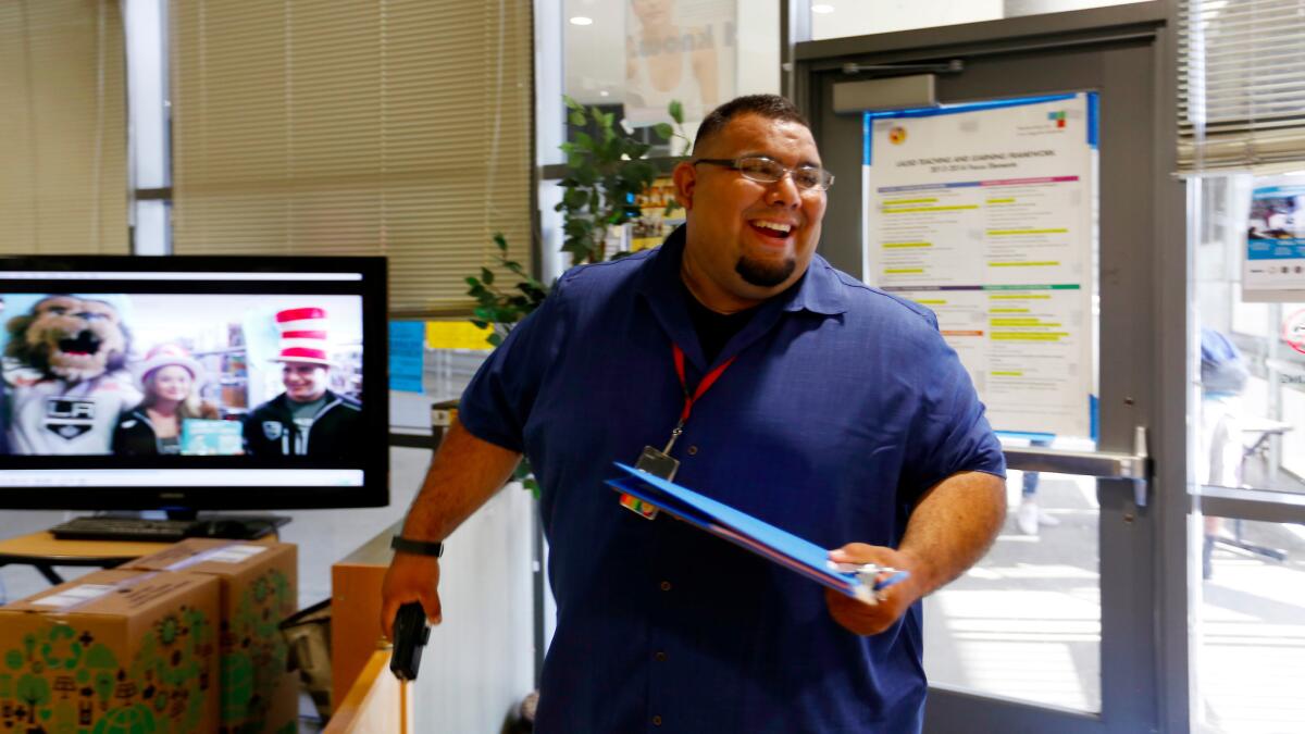 Jose Lara, left, dean of Santee Education Complex, goes door-to-door in an effort to find students who haven't reported to school.