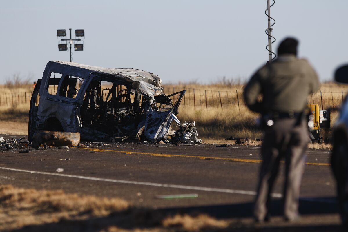 FILE - Texas Department of Public Safety Troopers look over the scene of a fatal car wreck early on March 16, 2022, half of a mile north of State Highway 115 on Farm-to-Market Road 1788 in Andrews County, Texas, where a pickup truck crossed the center line of a two-lane road in Andrews County, about 30 miles (50 kilometers) east of the New Mexico state line on Tuesday evening and crashed into a van carrying members of the University of the Southwest men's and women's golf teams, said Sgt. Steven Blanco of the Texas Department of Public Safety. The father of a 13-year-old boy, not the teen, was driving a pickup that struck the team's van federal officials said on Thursday, July 14 . (Eli Hartman/Odessa American via AP, File)