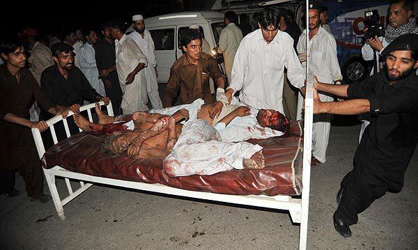 Pakistani men push a bed carrying blast victims at a Peshawar hospital.