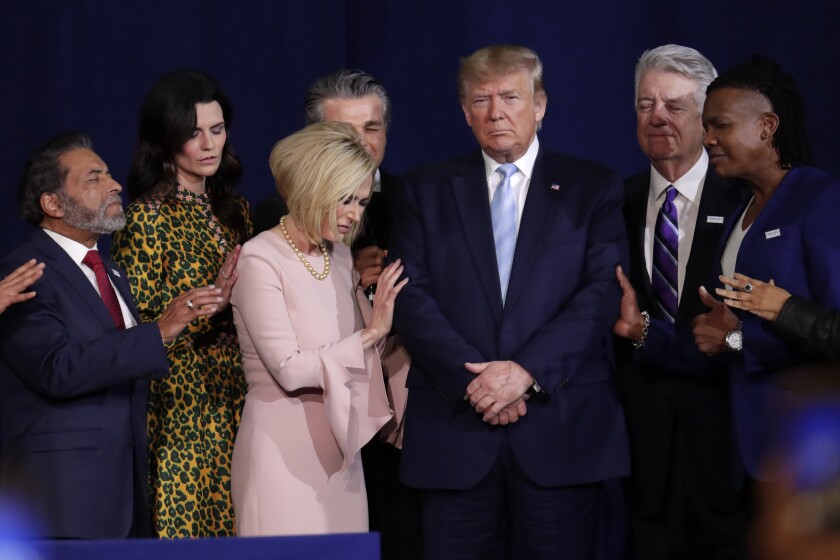 Faith leaders pray with President Trump during a rally earlier this year for evangelical supporters in Miami.