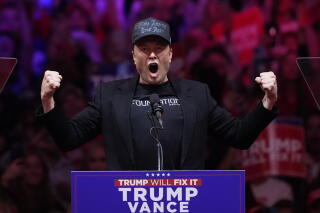 Elon Musk flexes and shouts into a microphone at a Trump-Vance campaign rally at Madison Square Garden