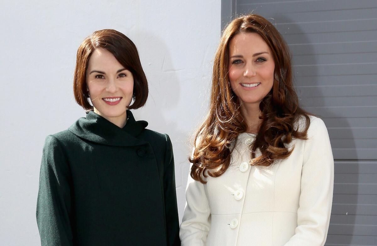 Britain's Catherine, Duchess of Cambridge, right, poses for pictures with actress Michelle Dockery who plays Lady Mary Crawley, during an official visit to the set of TV series "Downton Abbey" on March 12.