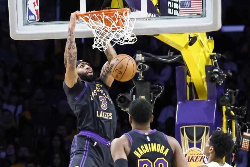Laker Anthony Davis dunks in front of teammate Rui Hachimura and the Jazz's Ochai Agbaji