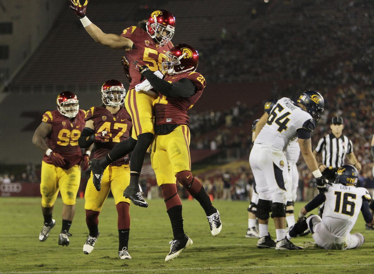USC safety Su'a Cravens (21) celebrates with linebacker Anthony Sarao (56) after a sack against California on Nov. 13. 2014.