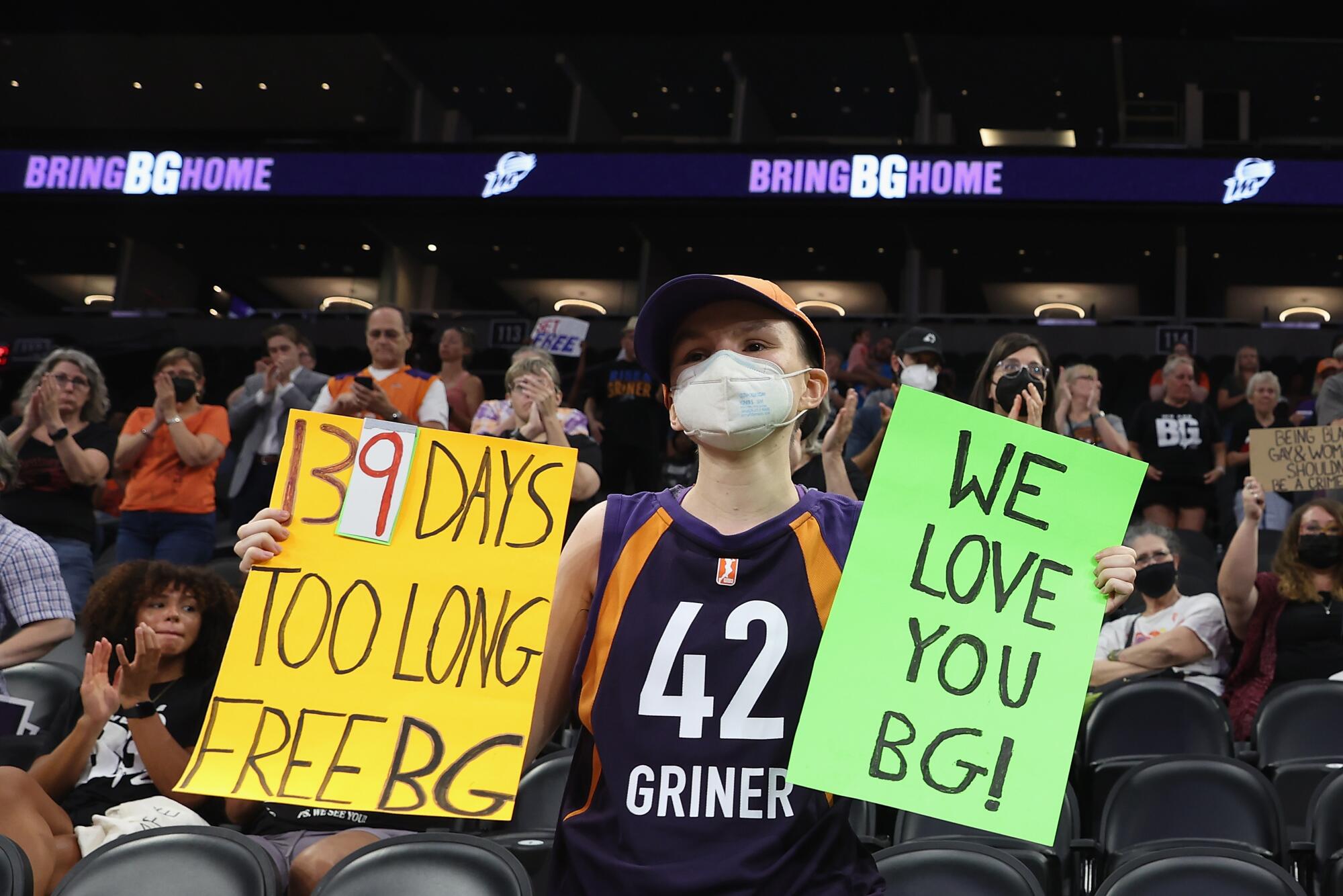 A supporter holds up signs during a rally in Phoenix to support Brittney Griner's release. 