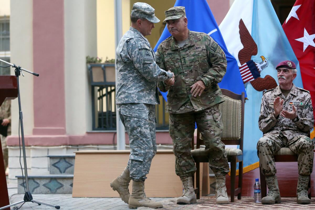 Gen. John F. Campbell, center, incoming commander of the International Security Assistance Force, shakes hands with U.S. Chairman of the Joint Chiefs of Staff Gen. Martin Dempsey during a change-of-command ceremony in Kabul, Afghanistan.