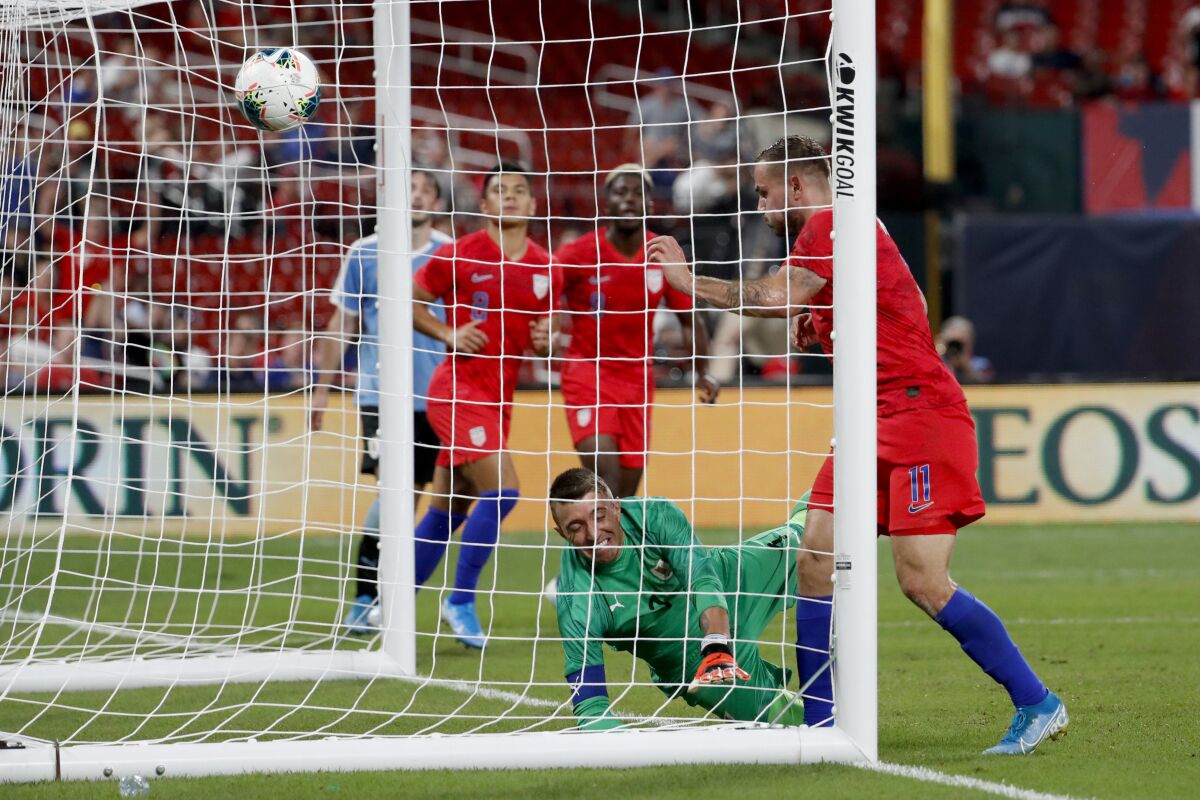 United States' Jordan Morris (11) scores past Uruguay goalkeeper Fernando Muslera during the second half of a friendly match on Tuesday in St. Louis. The game ended in a 1-1 tie.