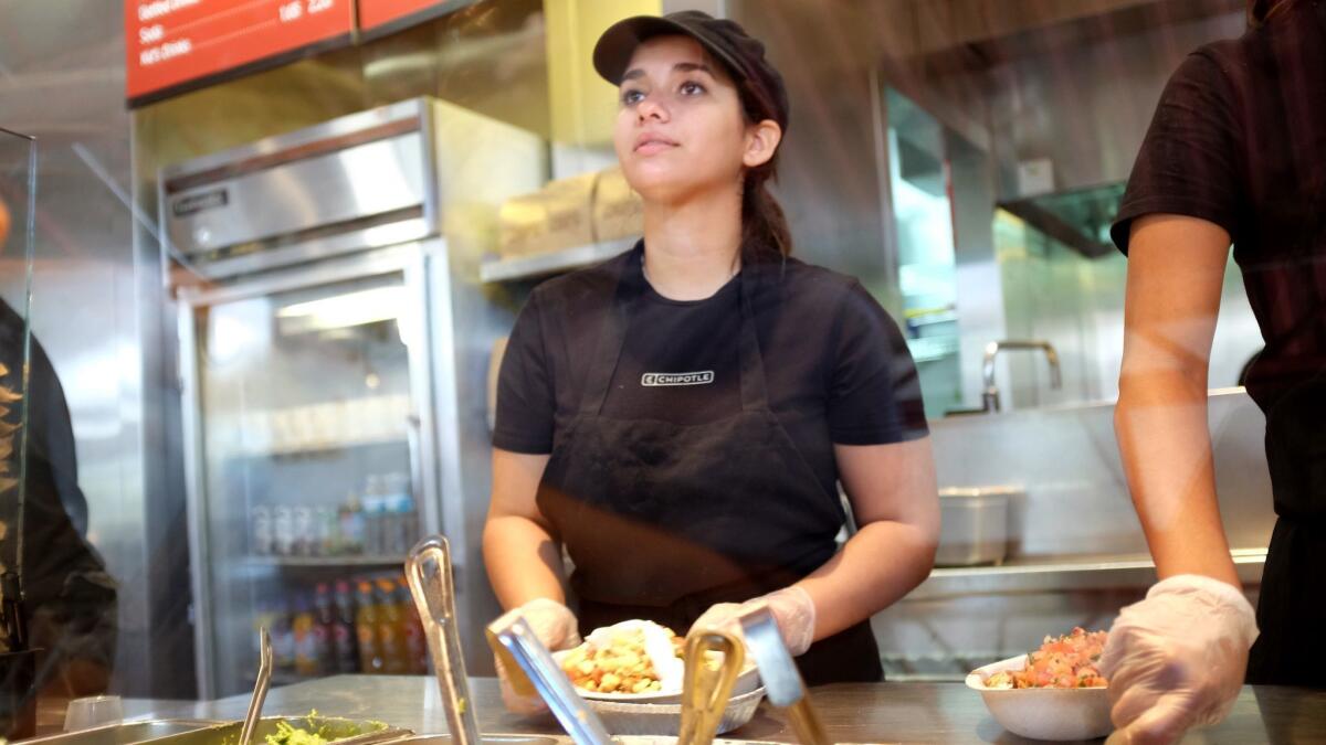 A Chipotle worker fills an order for a customer. The Mexican food chain and Oscar-winning documentary filmmaker Errol Morris are making a series of ads showcasing the restaurant’s fresh ingredients.