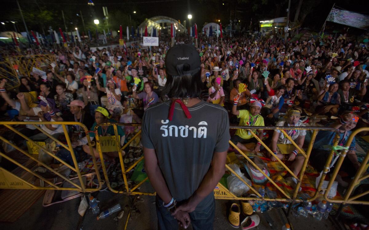 An antigovernment activist in Bangkok, Thailand, watches the crowd as protest leader Suthep Thaugsuban speaks to supporters after the nation's constitutional court nullified the results of a Feb. 2 election. Protesters, who have tried for four months to force Prime Minister Yingluck Shinawatra out of office, were cheered by the court action, which Yingluck's party denounced as biased.