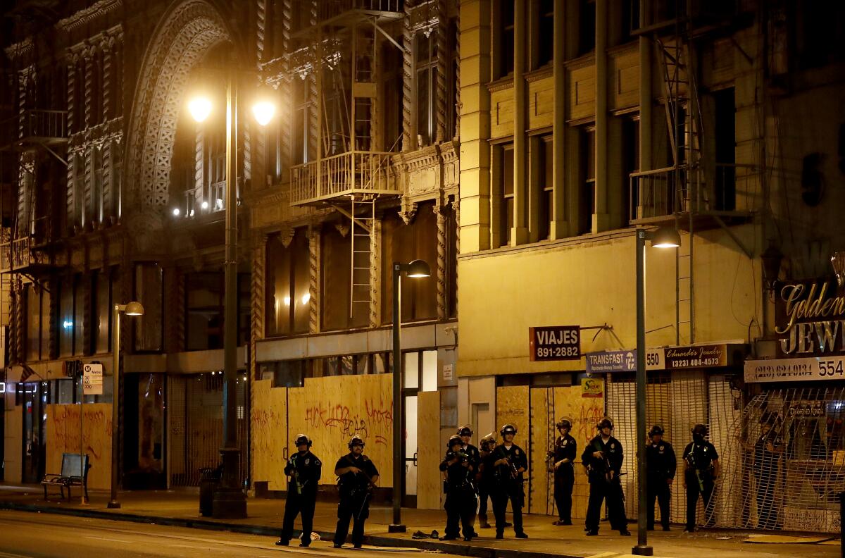 Police stand outside a looted store in downtown L.A.