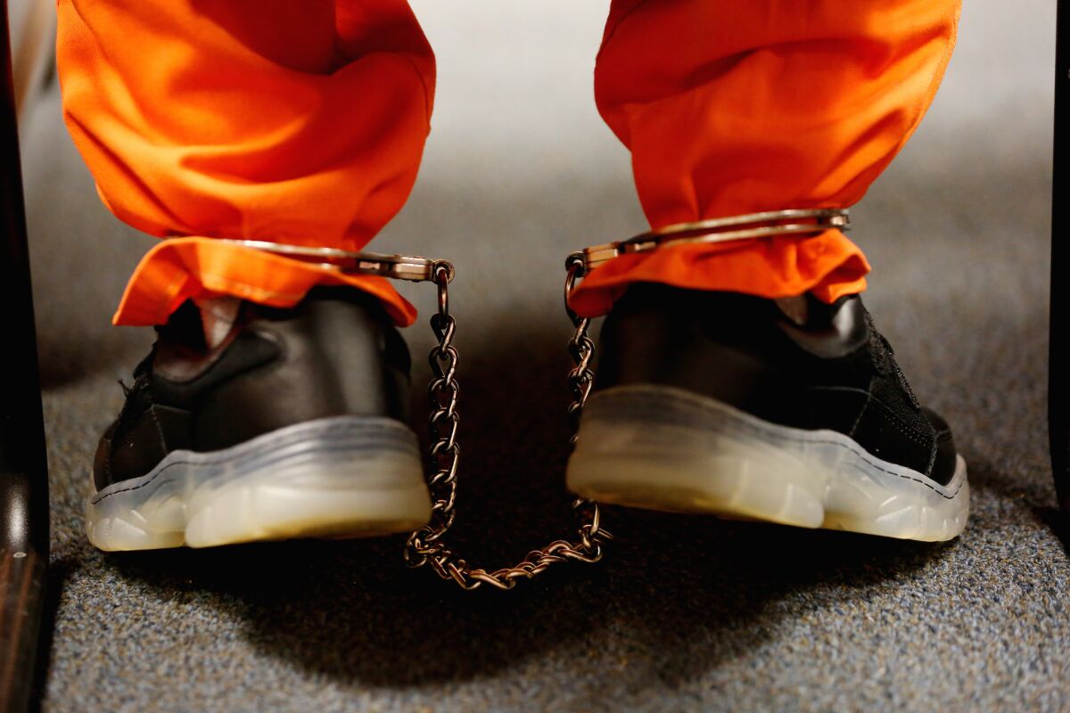 Close-up of metal cuffs around the ankles of a juvenile respondent in court