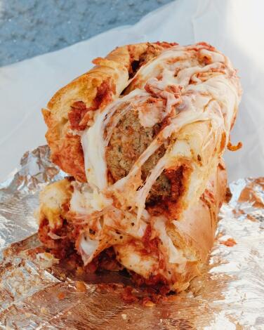 Two stacked halves of a meatball sub sandwich, gooey with cheese, at Cricca's Italian Deli in Woodland Hills