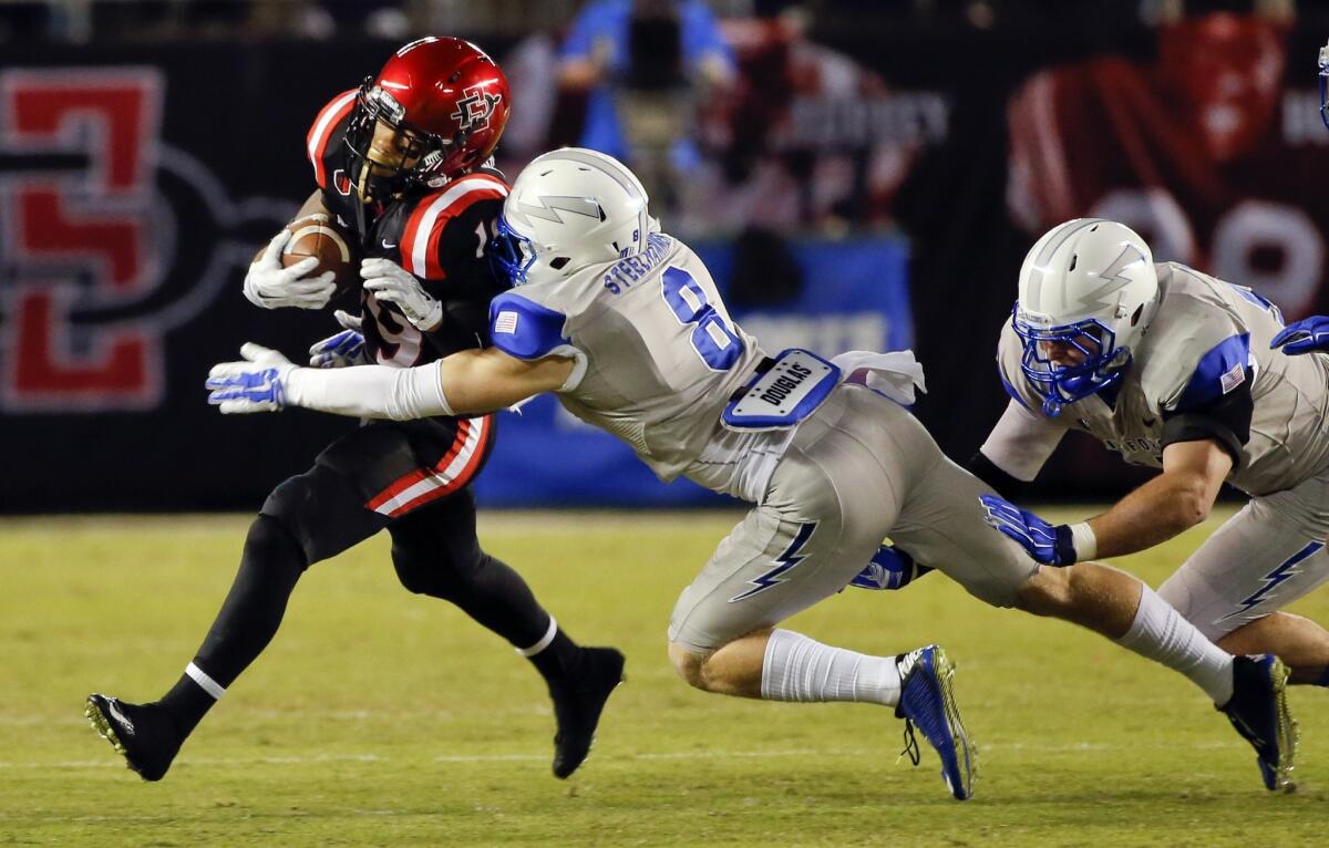 San Diego State running back Donnel Pumphrey, left, is stopped by Air Force defensive back Weston Steelhammer.