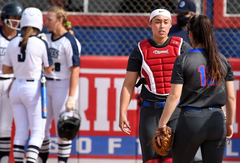 Los Alamitos catcher Sophia Nugent talks with a teammate during a timeout.