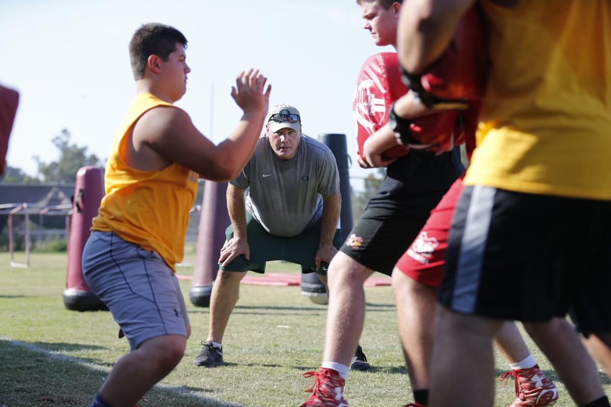 Oregon offensive line coach Steve Greenwood, center, watches high school football players run through drills during an Oregon satellite camp held at Mission Viejo High School.