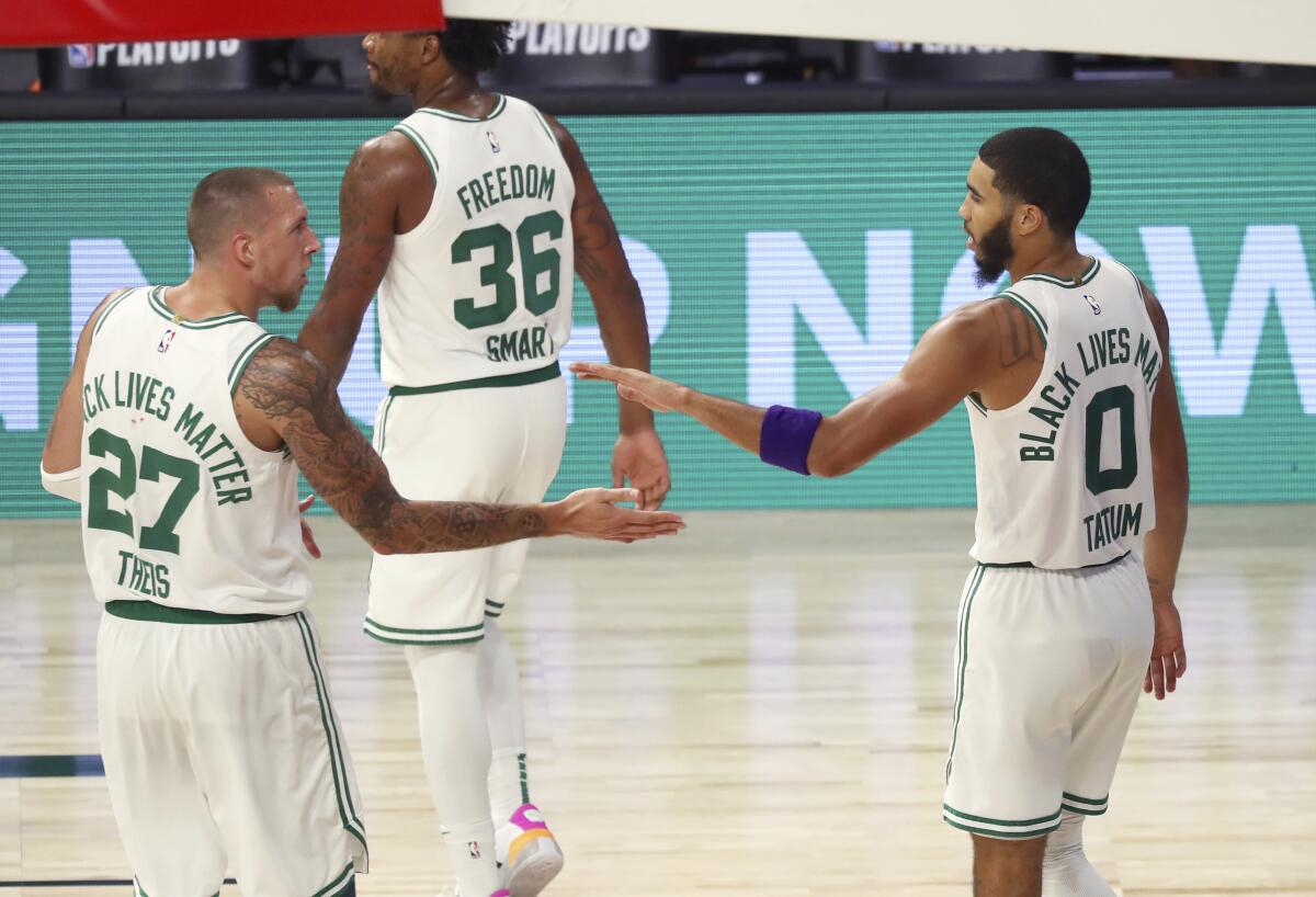 Boston Celtics forward Jayson Tatum (0) and center Daniel Theis (27)