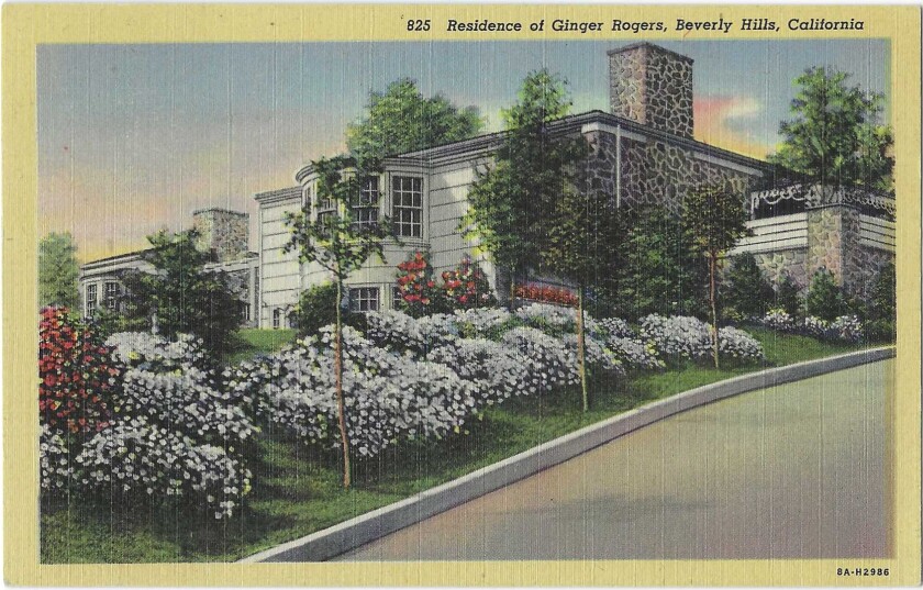 Stonework and whitewashed siding on the home, with white and red flowers outside.