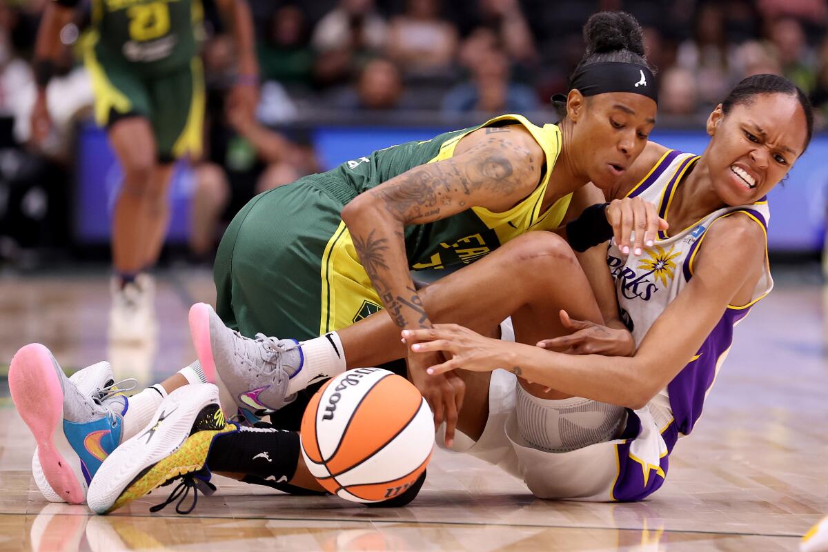 Seattle Storm's Yvonne Turner and Sparks' Azura Stevens dive for the ball during the second quarter in Seattle.