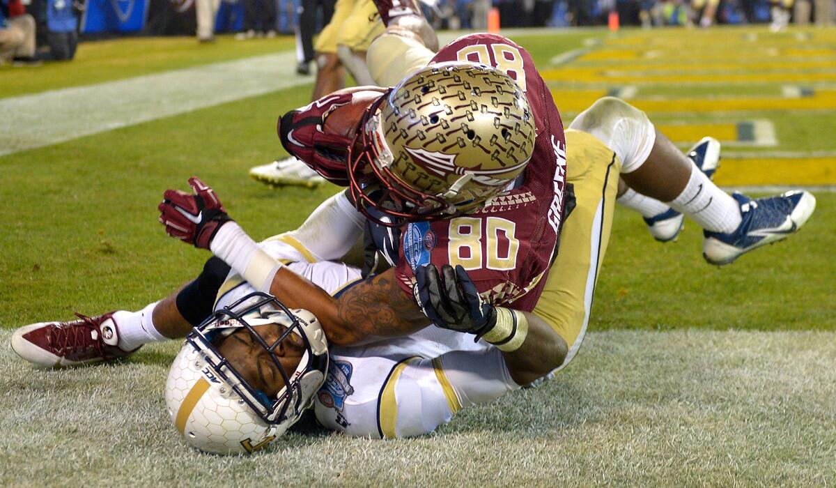 Florida State wide receiver Rashad Greene (80) falls out of bounds on top of Georgia Tech cornerback Jamal Golden after making a touchdown catch in the first half of the ACC championship game on Saturday night.